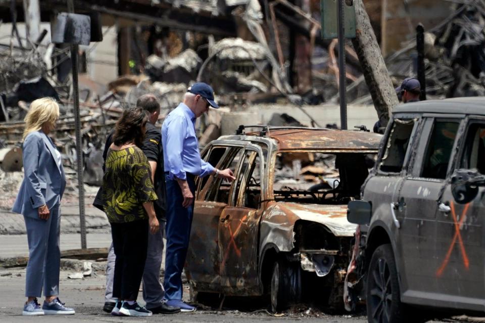 President Joe Biden and first lady Jill Biden look at a burned car with Hawaii Governor Josh Green and his wife Jaime Green as they visit areas devastated by the Maui wildfires, on August 21 (AP)