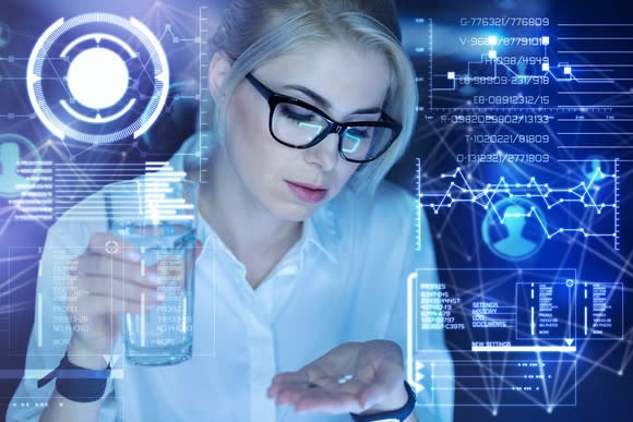 Woman with pill in hand and glass of water in the other hand