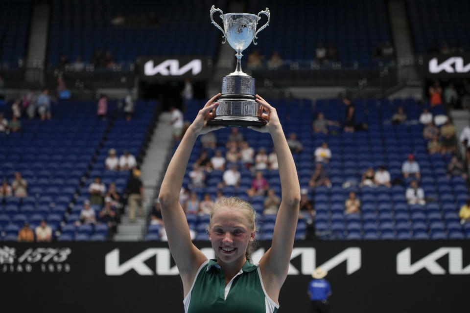 Alina Korneeva of Russia holds her trophy aloft after defeating compatriot Mirra Andreeva in the girls' singles final at the Australian Open tennis championship in Melbourne, Australia, Saturday, Jan. 28, 2023. (AP Photo/Aaron Favila)