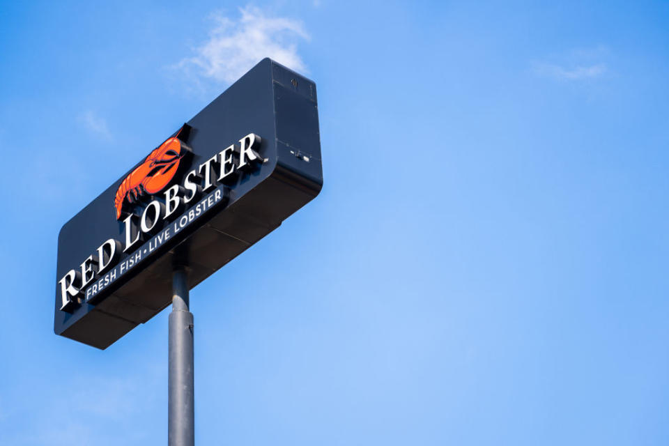 Red Lobster sign with text "FRESH FISH. LIVE LOBSTER" against a clear sky