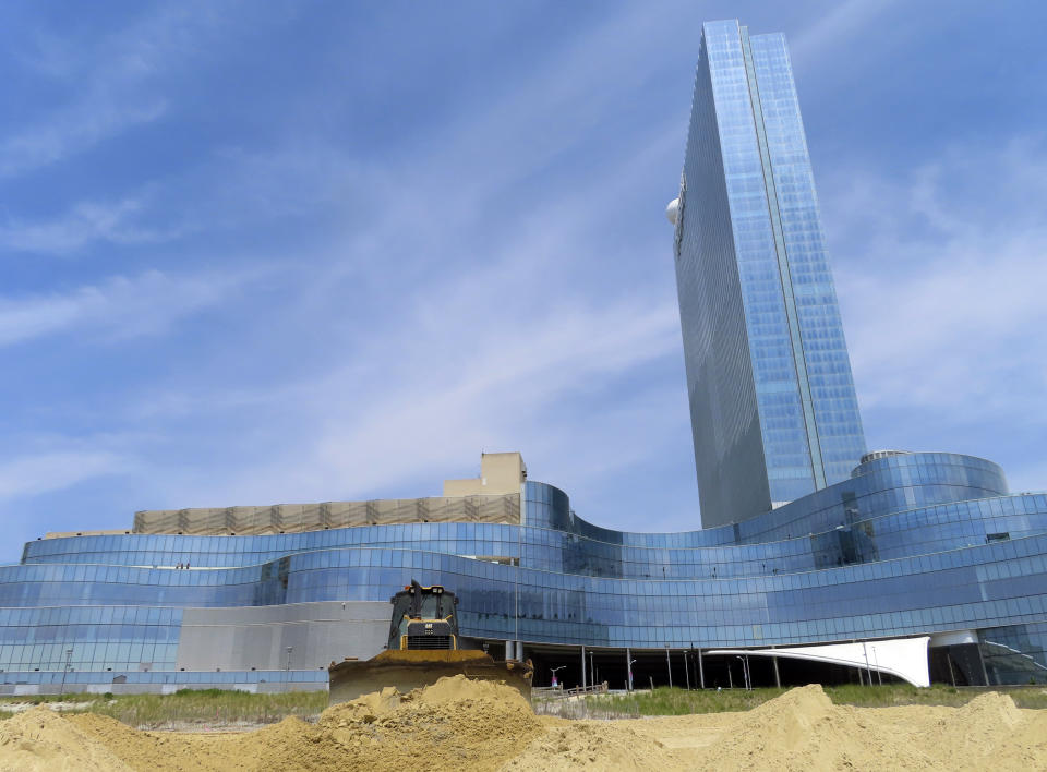 FILE - A bulldozer spreads freshly dumped sand on the beach in front of the Ocean Casino Resort in Atlantic City, N.J., Friday, May 12, 2023. The Ocean, Resorts and Hard Rock casinos want federal officials to expedite a beach replenishment project planned for 2024 so that it creates usable beaches this summer, but the U.S. Army Corps of Engineers says work might not start until the fall. (AP Photo/Wayne Parry, File)