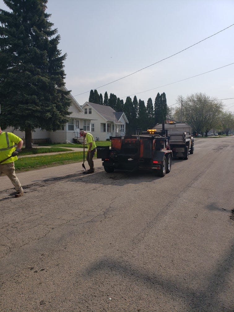 A crew from the Street Division of Oshkosh's Department of Public Works fills in some potholes in Oshkosh.