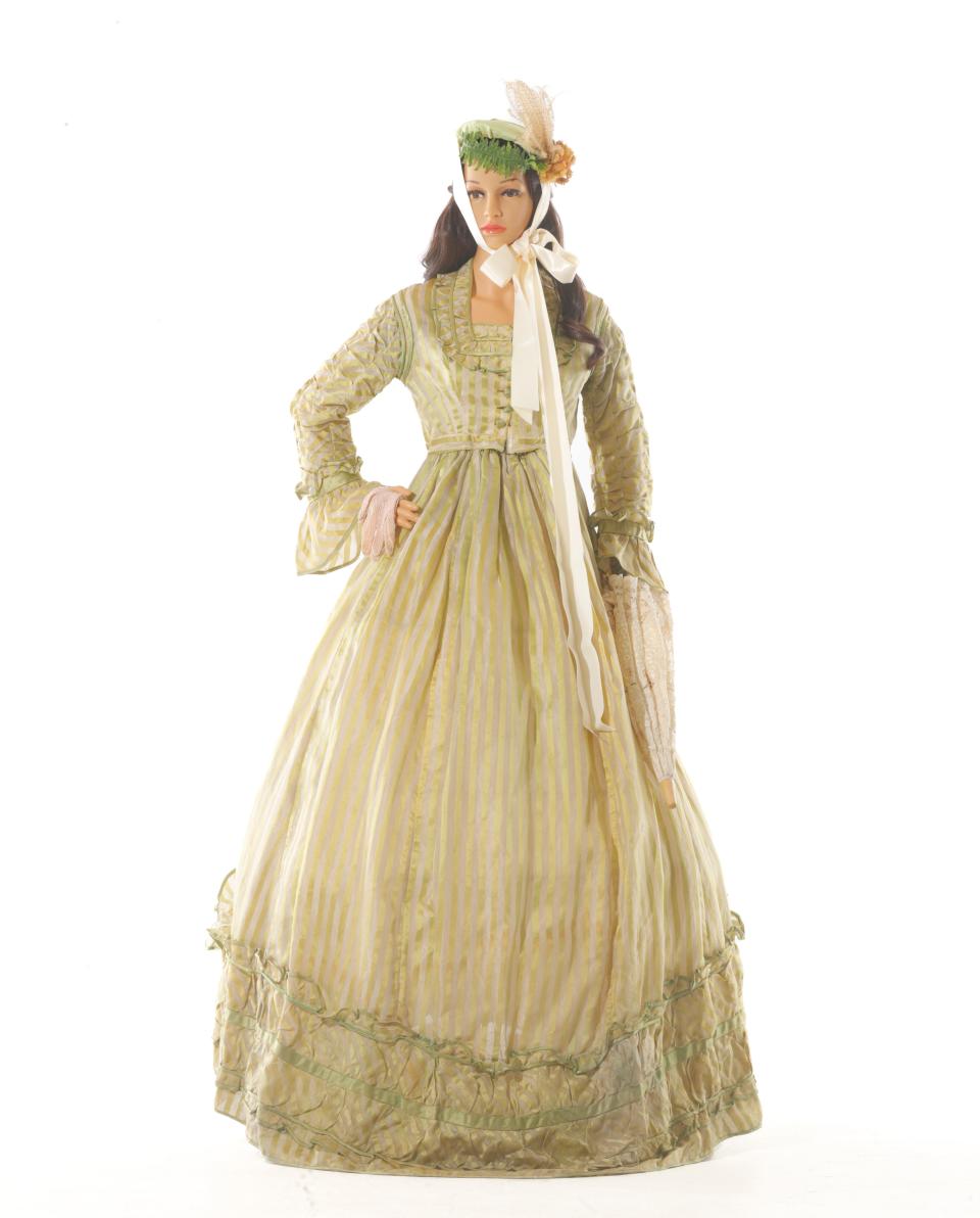 The 20th century women would have worn a Antebellum  two piece silk dress with a hoop skirt underneath, gloves, an embellished bonnet and a parosol to the Ketnucky Derby.  This dress is part of the Frazier History Museum's collection.