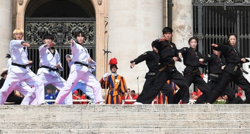 The martial arts athletes, half in white and half in black uniforms, performed for the pope in Saint Peter's Square