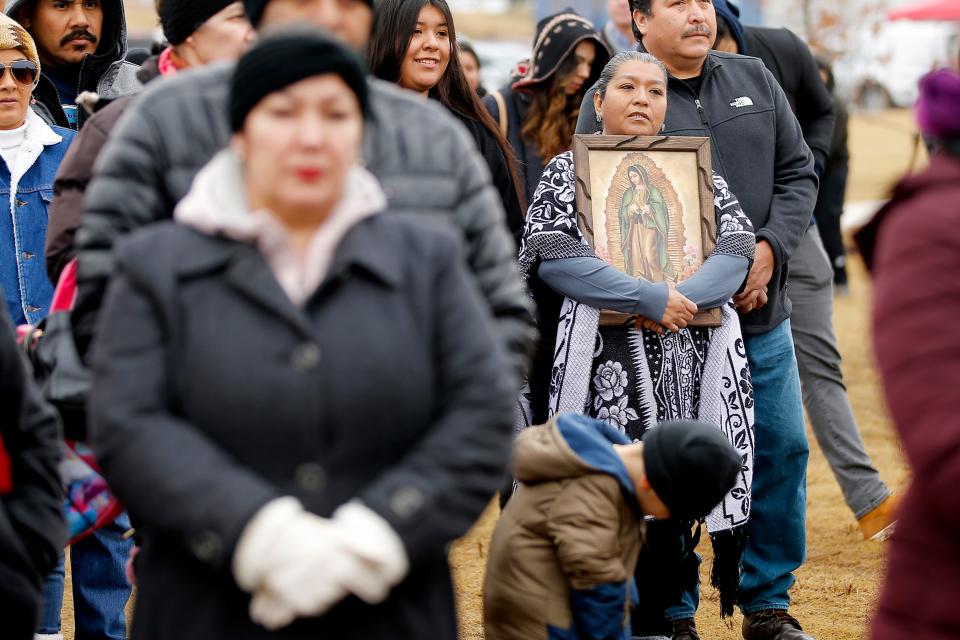 A woman stands during a prayer before an outdoor Mass and dedication of Tepeyac Hill on Sunday at the Blessed Stanley Rother Shrine in Oklahoma City.