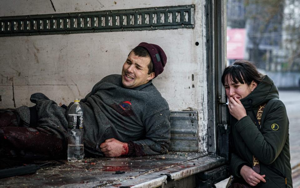 Una mujer reacciona junto a un hombre herido tras el bombardeo ruso a la ciudad ucraniana de Kherson