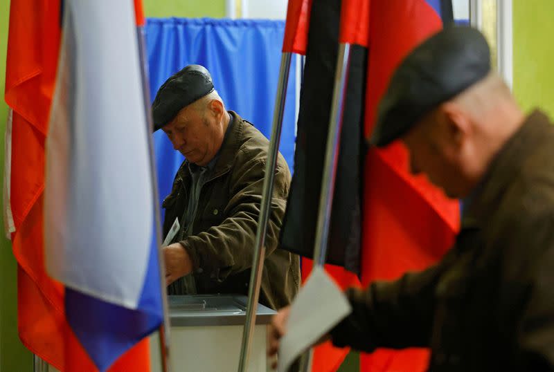 Un hombre deposita su voto en un colegio electoral durante las elecciones presidenciales rusas, en Donetsk, Ucrania, controlada por Rusia