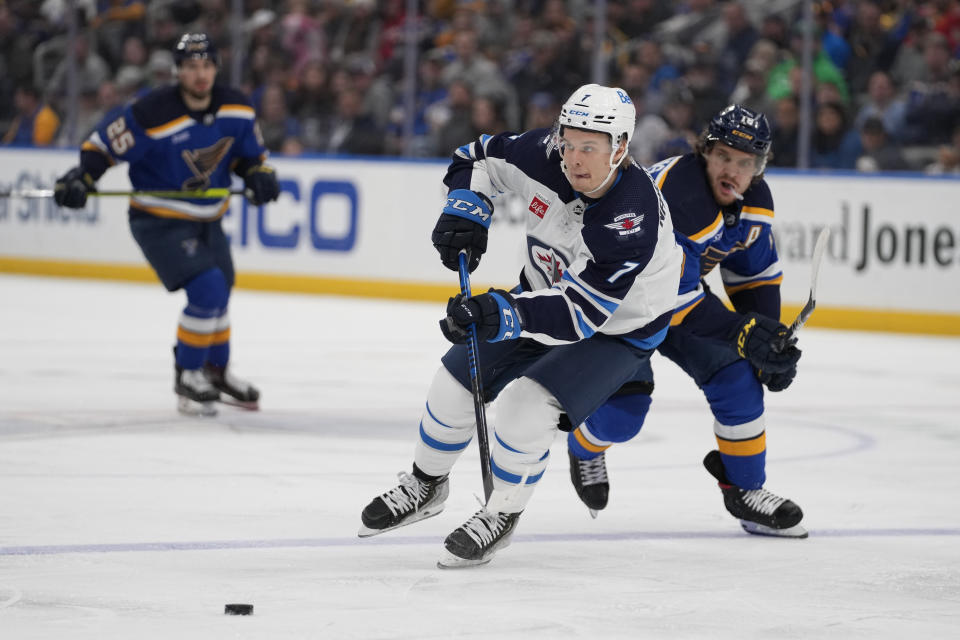 Winnipeg Jets' Vladislav Namestnikov (7) passes the puck as St. Louis Blues' Robert Thomas defends during the third period of an NHL hockey game Sunday, March 19, 2023, in St. Louis. (AP Photo/Jeff Roberson)