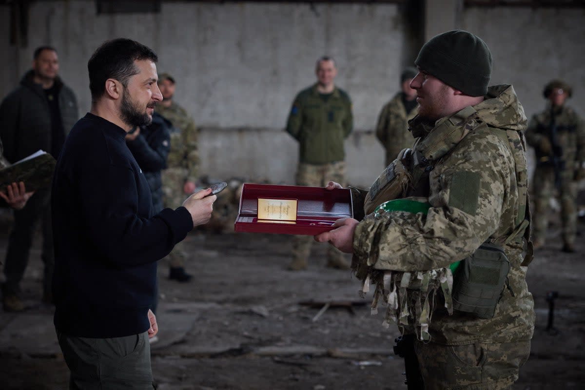 President Volodymyr Zelensky warding a serviceman with the Medal of Honor during a meeting with servicemen in a warehouse, near Bakhmut  (UKRAINIAN PRESIDENTIAL PRESS SER)