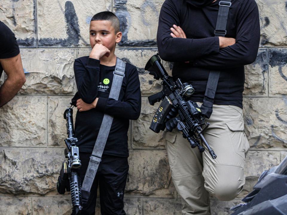 A Palestinian kid with an assault rifle attends the funeral of Aysar al-Amer, 25, a local commander in the Islamic Jihad militant group, and Jawad Turki, 19, in the West Bank city of Jenin.