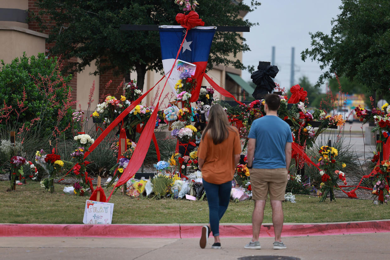 People look at a memorial to those killed at the Allen Premium Outlets mall after the mass shooting in Allen, Texas