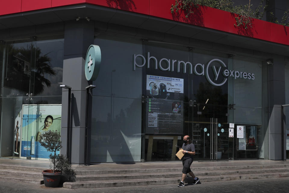 A man passes by a closed pharmacy in Beirut, Lebanon, Friday, June 11, 2021. Pharmacies across Lebanon began a two-day strike Friday, protesting severe shortages in medicinal supplies that is increasingly putting them in confrontation with customers and patients searching for medicines. The shortages are affecting everything from medicines for chronic illnesses to pain relievers to infant milk. (AP Photo/Bilal Hussein)