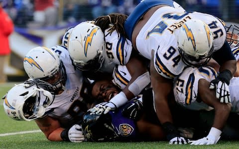 Inside linebacker Donald Butler #56 of the San Diego Chargers loses his helmet while making a fourth quarter tackle on running back Justin Forsett #29 of the Baltimore Ravens at M&T Bank Stadium on November 30, 2014 in Baltimore, Maryland - Credit: Getty Images