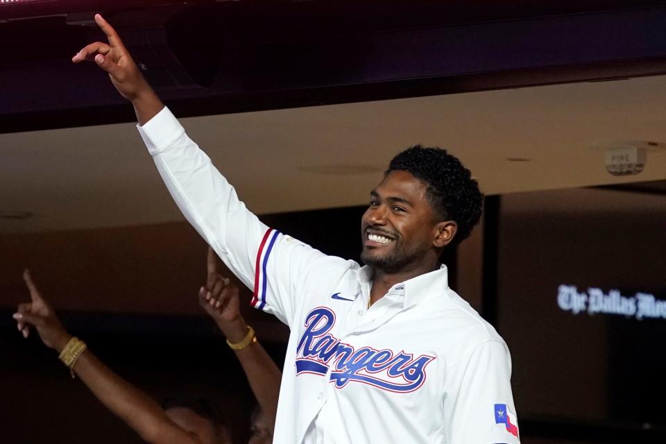 Texas Rangers' Kumar Rocker acknowledges applause from fans after being introduced on the public address system, during the second inning of the Rangers' baseball game against the Chicago White Sox, Thursday, Aug. 4, 2022, in Arlington, Texas. Rocker will spend a few more days around the Texas Rangers before going to Arizona, where the third overall draft pick is expected to make his organizational debut in the fall instructional league. (AP Photo/Tony Gutierrez)