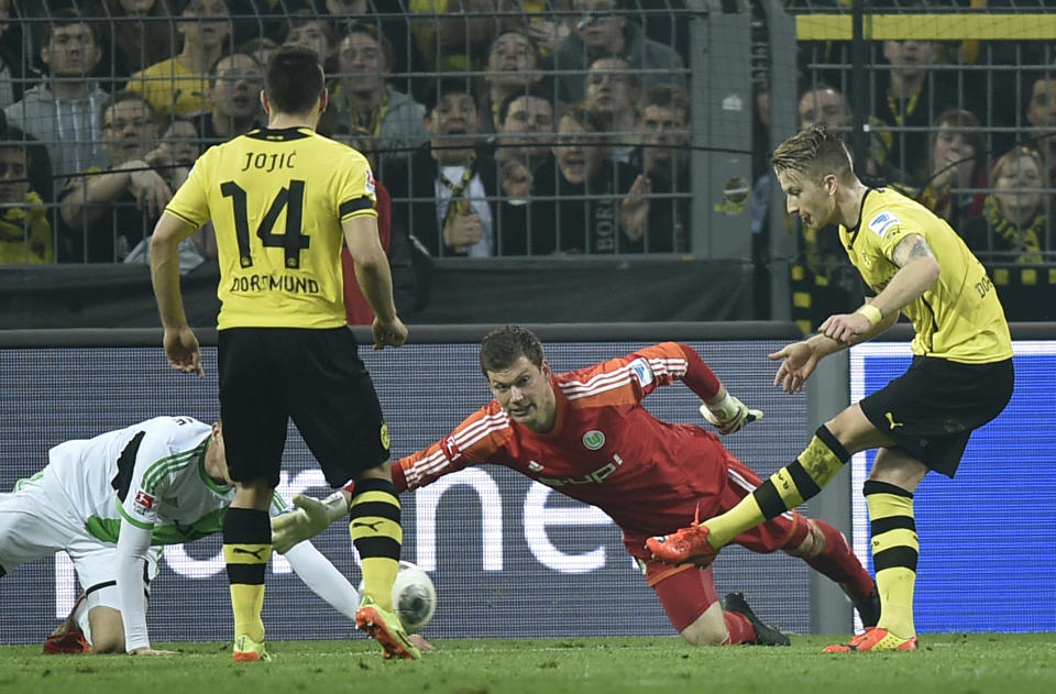 Dortmund's Marco Reus, right, scores a goal against Wolfsburg goalkeeper Max Gruen during the German Bundesliga soccer match between Borussia Dortmund and VfL Wolfsburg in Dortmund, Germany, Saturday, April 5, 2014, 2014. (AP Photo/Martin Meissner)