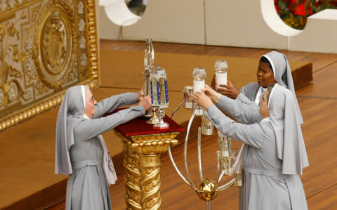 Nuns place on the altar the relics of five new saints during an open-air canonization ceremony led by Pope Benedict XVI, in St. Peter's Square at the Vatican, in 2009. - Credit: AP