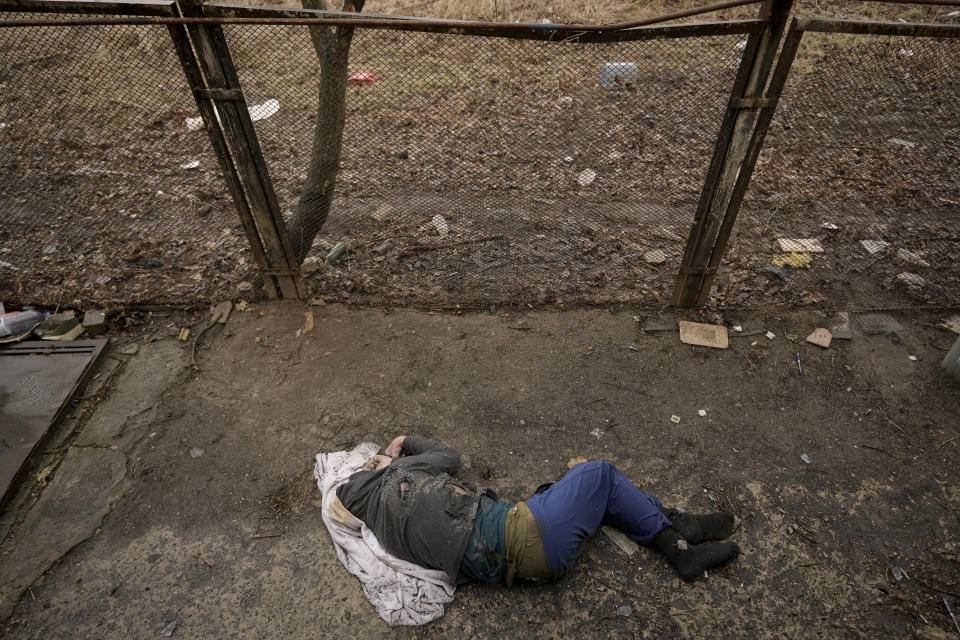 FILE - The lifeless body of a man lies on the ground, in Bucha, Ukraine, Sunday, April 3, 2022. Russian soldiers in intercepted phone conversations called their sweeps of Bucha and other towns outside Kyiv “zachistka” – cleansing. They hunted people on lists prepared by their intelligence services and went door to door to identify and neutralize potential threats. When troops unable to reach Kyiv faced mounting losses, they became more erratic, conducting their sweeps with rising levels of sometimes drunken violence. (AP Photo/Vadim Ghirda, File)