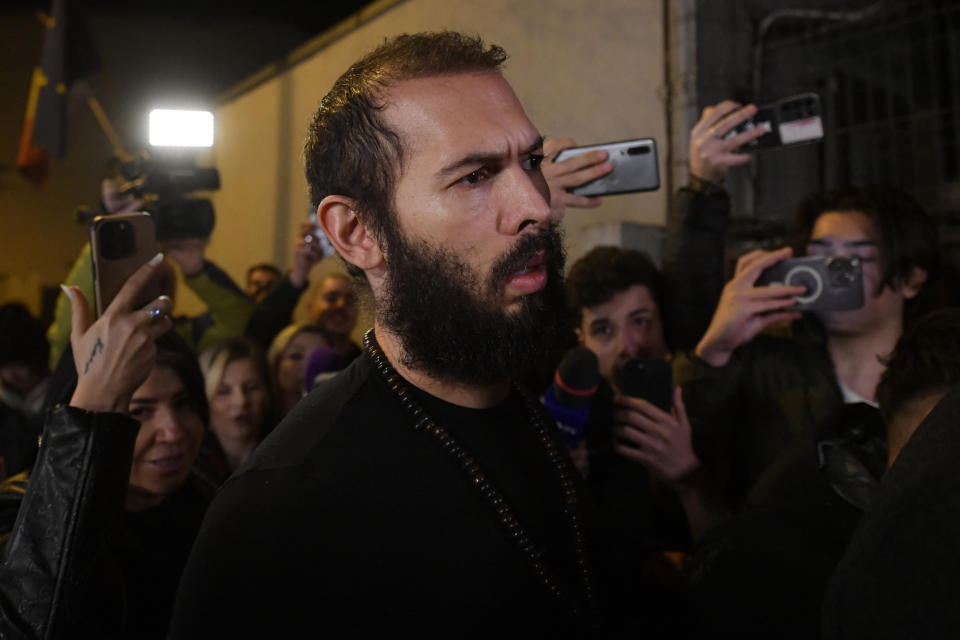 Young fans and media surround Andrew Tate as he leaves a police detention facility in Bucharest, Romania, after his release from prison on Friday March 31, 2023. An official on Friday said Tate, the divisive internet personality who has spent months in a Romanian jail on suspicion of organized crime and human trafficking, has won an appeal to replace his detention with house arrest. (AP Photo/Alexandru Dobre)