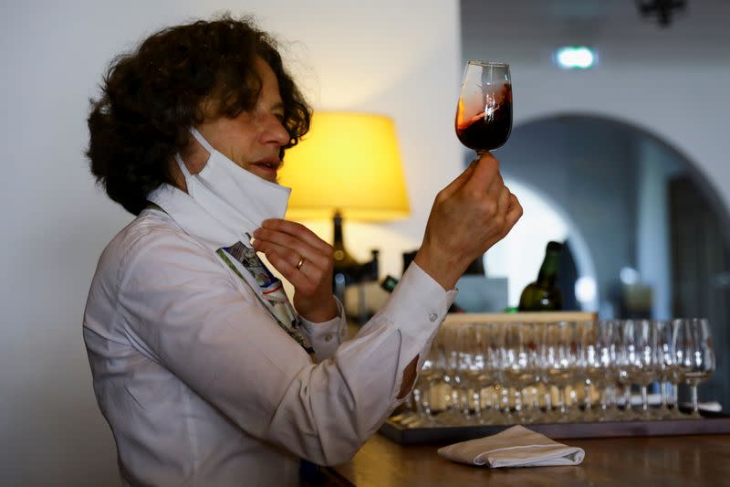 Taylor's Port Wine cellars' staff showcases a glass of Port wine, in Porto