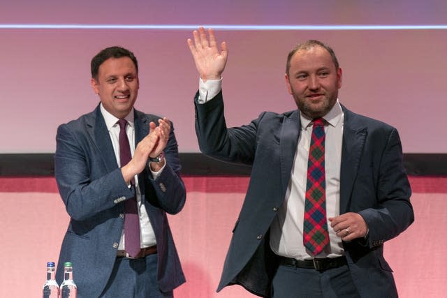 Anas Sarwar clapping as Ian Murray waves, following a speech