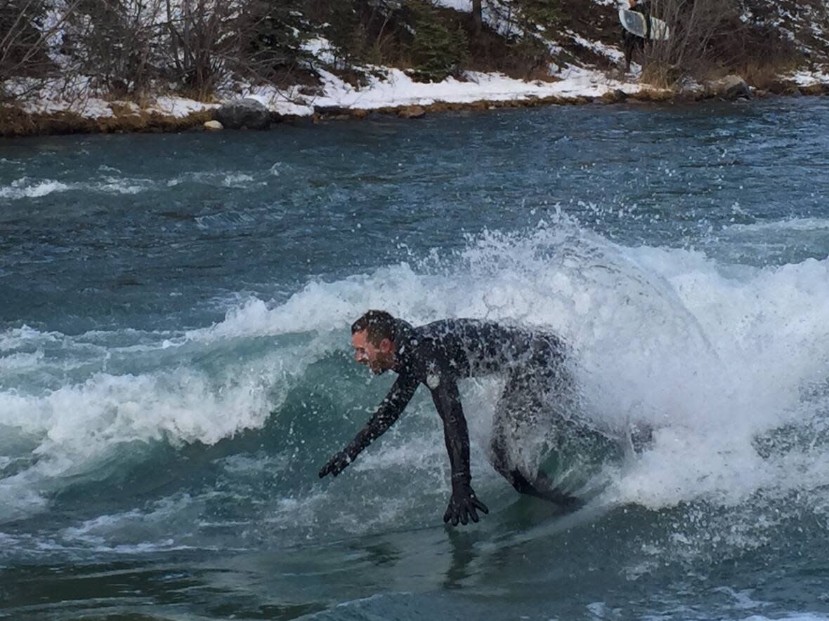 A river wave can be surfed for as long as the rider can stay upright.  (Erin Collins/CBC - image credit)