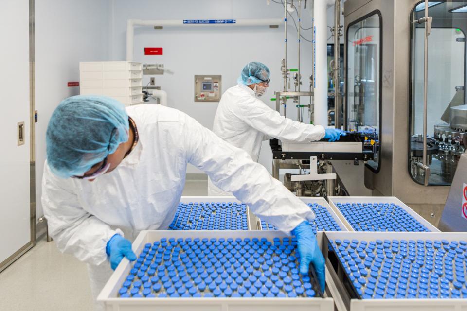 Lab technicians with vials of remdesivir