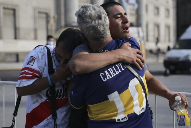 Fans of rival teams Boca Juniors, right, and River Plate, left, embrace 