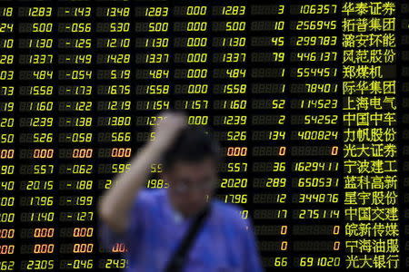 An investor stands in front of an electronic board showing stock information at a brokerage house in Shanghai, China, August 24, 2015. REUTERS/Aly Song