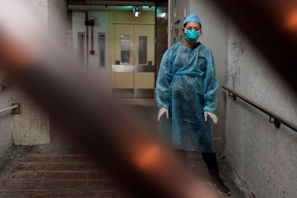 A personnel wearing protective suit waits near an entrance at the Cheung Hong Estate, a public housing estate during evacuation of residents in Hong Kong, Tuesday, Feb. 11, 2020. The Centre for Health Protection of the Department of Health evacuated some residents from the public housing estate after two cases of novel coronavirus infection to stop the potential risk of further spread of the virus. (AP Photo/Kin Cheung)