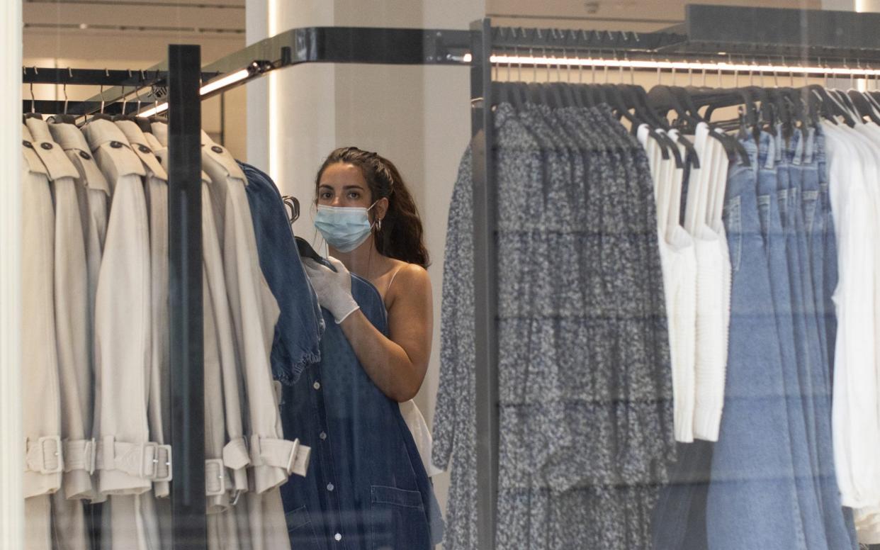 A worker changes clothes rails in a store on Oxford Street on May 19, 2020 in London, England. As shops gear up to open after a long period of closure, clothing stores are beginning to prepare to open their doors, and analysts have suggested that big discounts could be on offer as out of season stock is cleared. The British government has started easing the lockdown it imposed two months ago to curb the spread of Covid-19, abandoning its 'stay at home' slogan in favour of a message to 'be alert', but UK countries have varied in their approaches to relaxing quarantine measures - Dan Kitwood/Getty Images