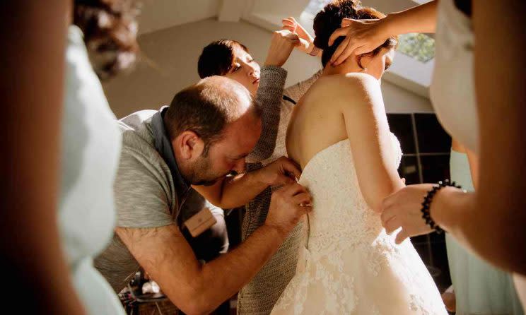  Ibrahim Halil Dudu fixing the zip on Jo Du’s wedding dress. The Syrian tailor and his family were being hosted by neighbour David Hobson and had only moved in four days previously. (Lindsay Coulter Photography/lindsaycoulterphoto.com )