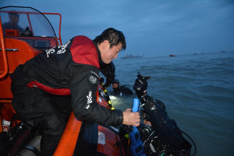 In a photo taken and released by the South Korean Coast Guard on April 18, 2014, South Korean divers prepare to search for passengers aboard a capsized ferry at sea off Jindo