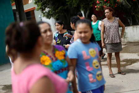 Felina, 50, an indigenous Zapotec transgender woman also know as Muxe, speaks with her neighbors outside her house destroyed after an earthquake that struck on the southern coast of Mexico late on Thursday, in Juchitan, Mexico, September 10, 2017. REUTERS/Edgard Garrido