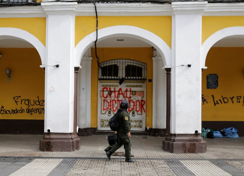 Police officers walk in front of the governorate building in Cochabamba