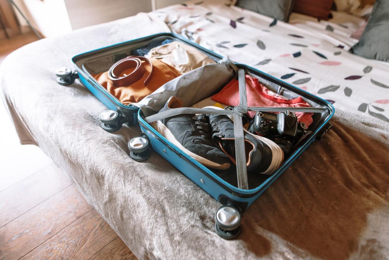 An open, full suitcase on a bed