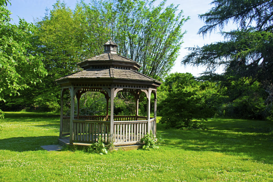 A gazebo sitting on lush grass at the Rutgers Gardens