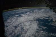 This unprecedented view of the space shuttle Atlantis, appearing like a bean sprout against clouds and city lights shows the shuttle on its way home as photographed by the Expedition 28 crew of the International Space Station through a window of the station in this July 21, 2011 NASA handout photo. Airglow over Earth can be seen in the background. The Atlantis and its four-member crew returned to the Kennedy Space Center in Florida on Thursday after a mission to resupply the International Space Station, ending a 12-year program to build and service the orbital research outpost. REUTERS/NASA/Handout (SCI TECH IMAGES OF THE DAY) FOR EDITORIAL USE ONLY. NOT FOR SALE FOR MARKETING OR ADVERTISING CAMPAIGNS. THIS IMAGE HAS BEEN SUPPLIED BY A THIRD PARTY. IT IS DISTRIBUTED, EXACTLY AS RECEIVED BY REUTERS, AS A SERVICE TO CLIENTS