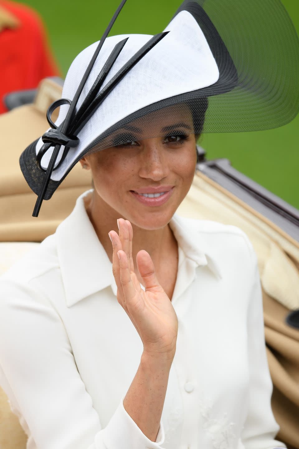 <p>Meghan Markle donned a cream Givenchy dess and Philip Treacy hat.</p>