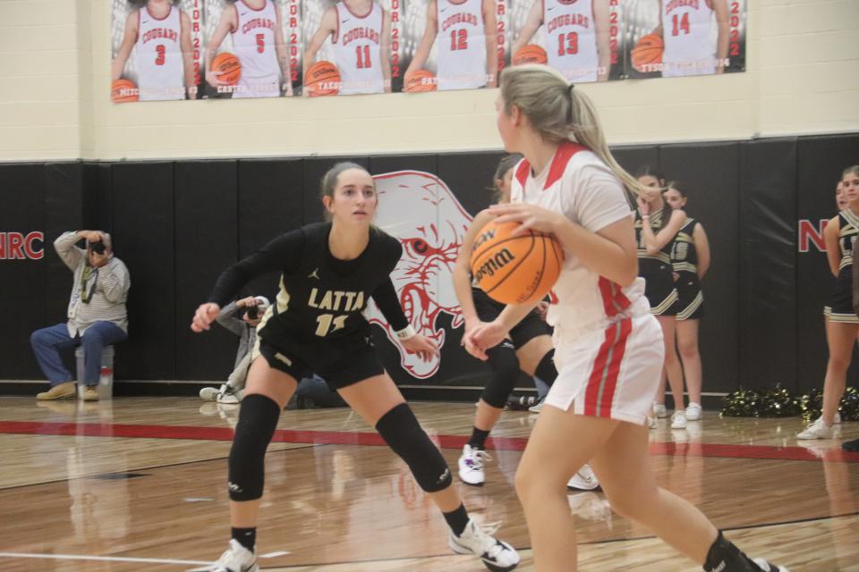 North Rock Creek's Olivia McRay (with ball) looks to make an entry pass against the defense of Latta's Jaylee Willis.