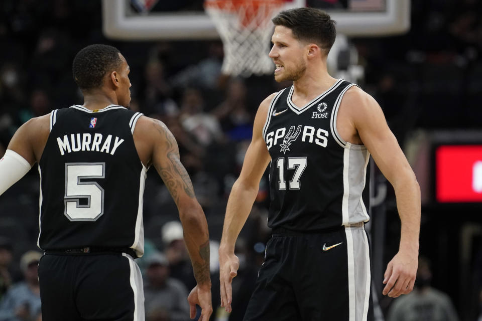San Antonio Spurs guard Dejounte Murray (5) and forward Doug McDermott (17) celebrate a score against the Oklahoma City Thunder during the second half of an NBA basketball game, Wednesday, Jan. 19, 2022, in San Antonio. (AP Photo/Eric Gay)