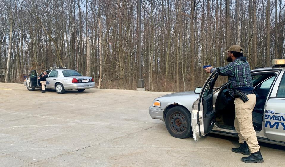 Canton police cadet Jamaal McClain aims his gun at a suspect during a high-risk traffic stop training at the Stark State College law enforcement academy in Jackson Township.