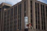 A worker dismantles a Twitter's sign at Twitter's corporate headquarters building in San Francisco