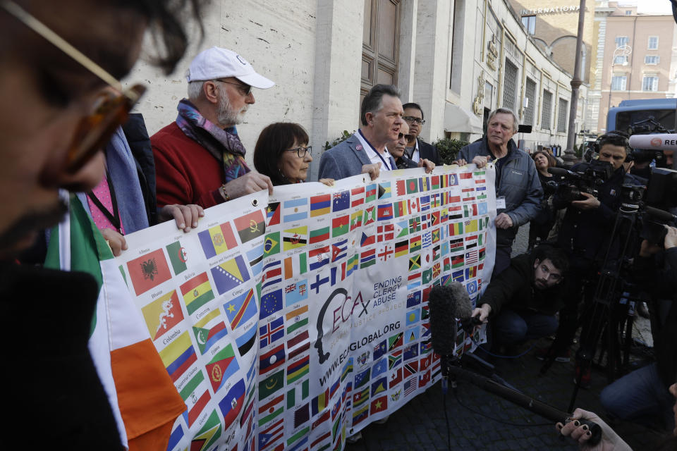 Sex abuse survivors and members of the ECA (Ending Clergy Abuse) hold their organization banner as they talk to journalists, as some of their representatives are meeting with organizers of the summit on preventing sexual abuse at the Vatican, Wednesday, Feb. 20, 2019. A dozen survivors of clergy sexual abuse met with organizers of Pope Francis' landmark summit on preventing abuse and protecting children. Chilean survivor Juan Carlos Cruz, who was asked by the Vatican to invite survivors to the meeting, told reporters Wednesday that Francis would not be attending, as had been rumored. (AP Photo/Gregorio Borgia)