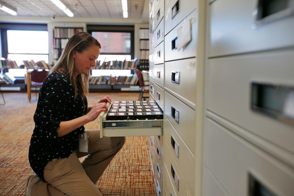 New Bedford public library reference librarian, Amy Ferguson, searches for the microfilm containing an online requested Standard-Times obituary, which she will then scan using a new state of the art scanner.