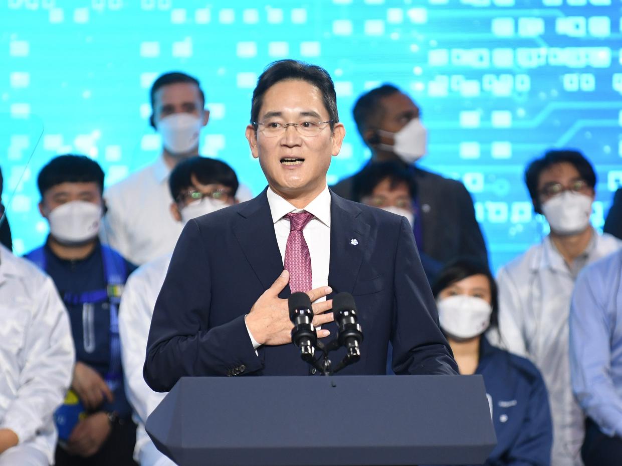 Samsung Electronics Vice Chairman Lee Jae-yong speaking in front of a group of masked people.