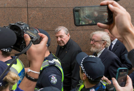 Vatican Treasurer Cardinal George Pell is surrounded by Australian police and members of the media as he leaves the Melbourne Magistrates Court in Australia, July 26, 2017. REUTERS/Mark Dadswell/Files