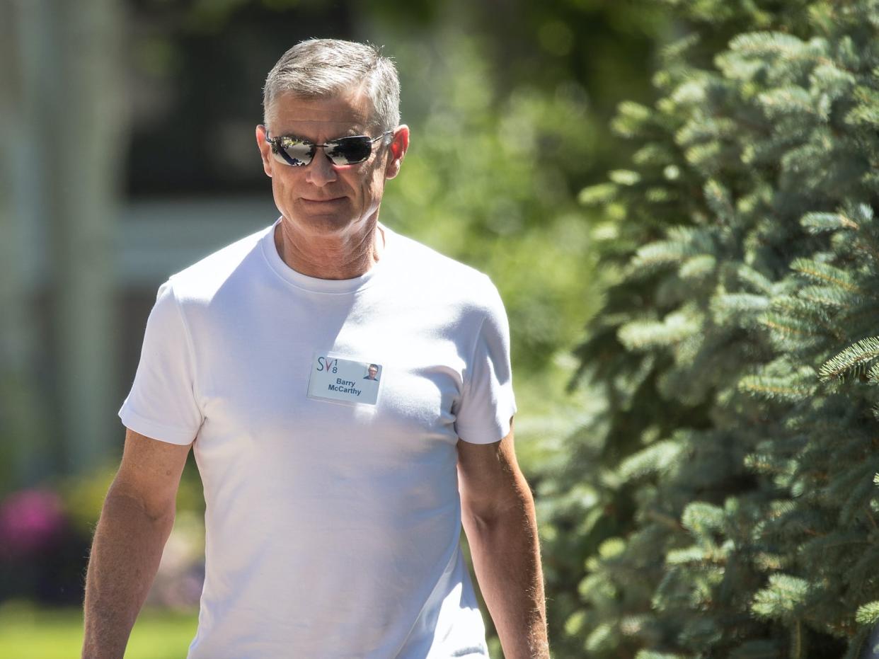 Barry McCarthy, wearing a white T-shirt, walks outside alongside his wife Valerie, at the Sun Valley, Idaho conference.