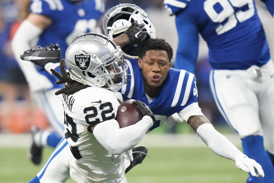 Indianapolis Colts cornerback Jaylon Jones, right, loses his helmet as he tackles Las Vegas Raiders running back Ameer Abdullah (22) during the first half of an NFL football game Sunday, Dec. 31, 2023, in Indianapolis. (AP Photo/AJ Mast)