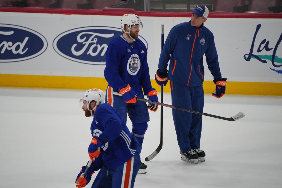 Edmonton Oilers coach Kris Knoblauch talks with left wing Warren Foegele (37) as center Connor McDavid (97) skates by during Friday's practice in Sunrise.