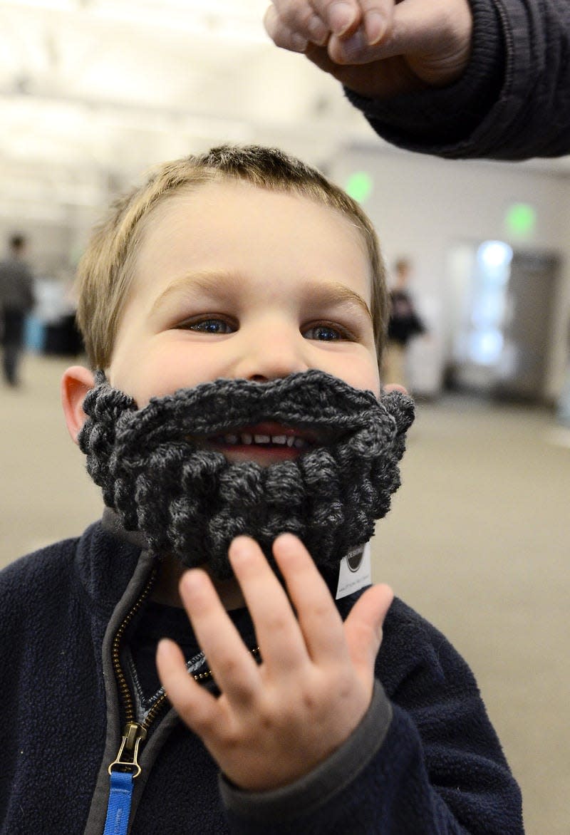 Asher Hahn, 3, pats down his crochet beard during the Handmade Market at the convention center in this undated file photo. Asher’s parents, Australian natives Matthew and Leonie Hahn, bought their sons, Asher and Tristan, 6, gray and blond crochet beards, which the boys wore as they visited various booths.